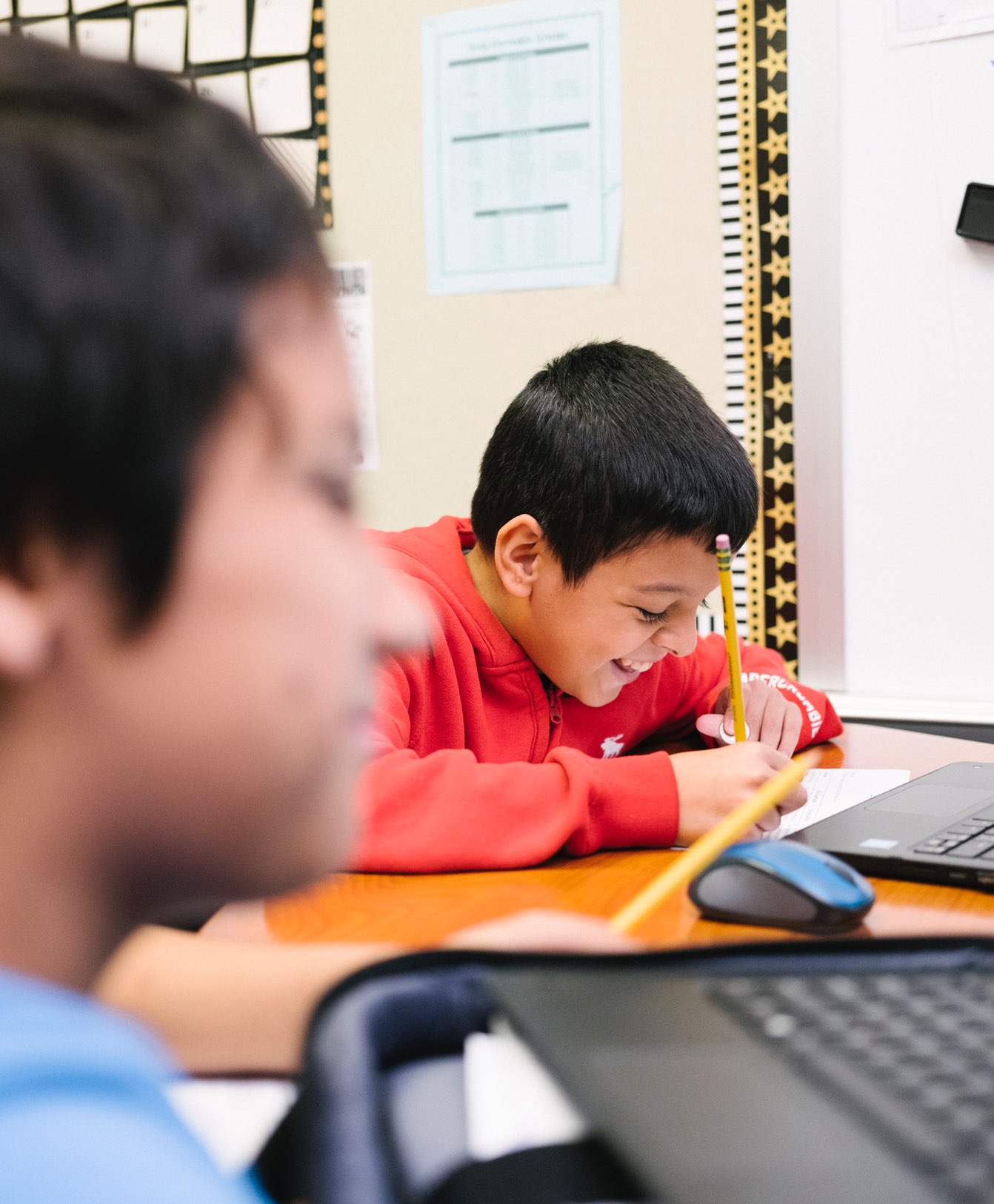 Two boys with pencils and laptop computers work together on their Summit Learning project at Bondy Intermediate School in Pasadena, Texas (Education, CZI).