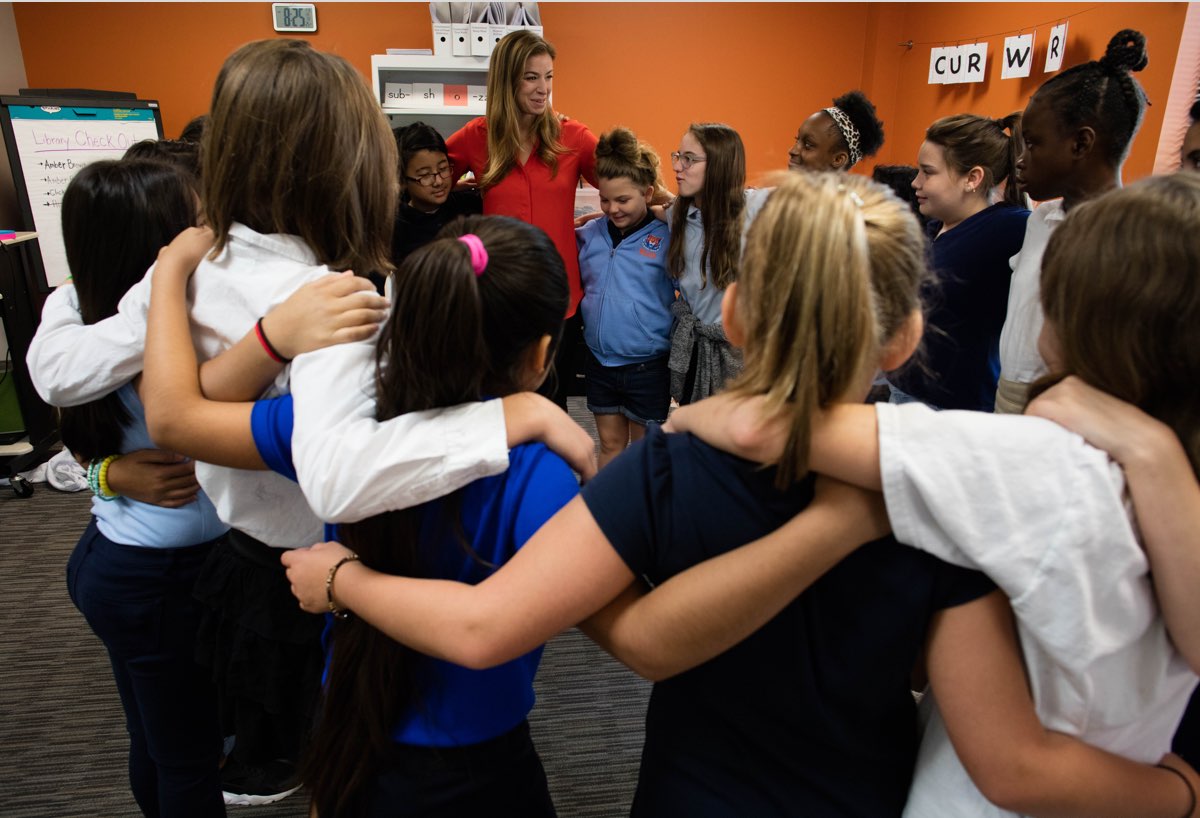 A teacher and her young students with arms around each other in their weekly Circle practice, at Valor Flagship Academy in Nashville (Education, CZI).