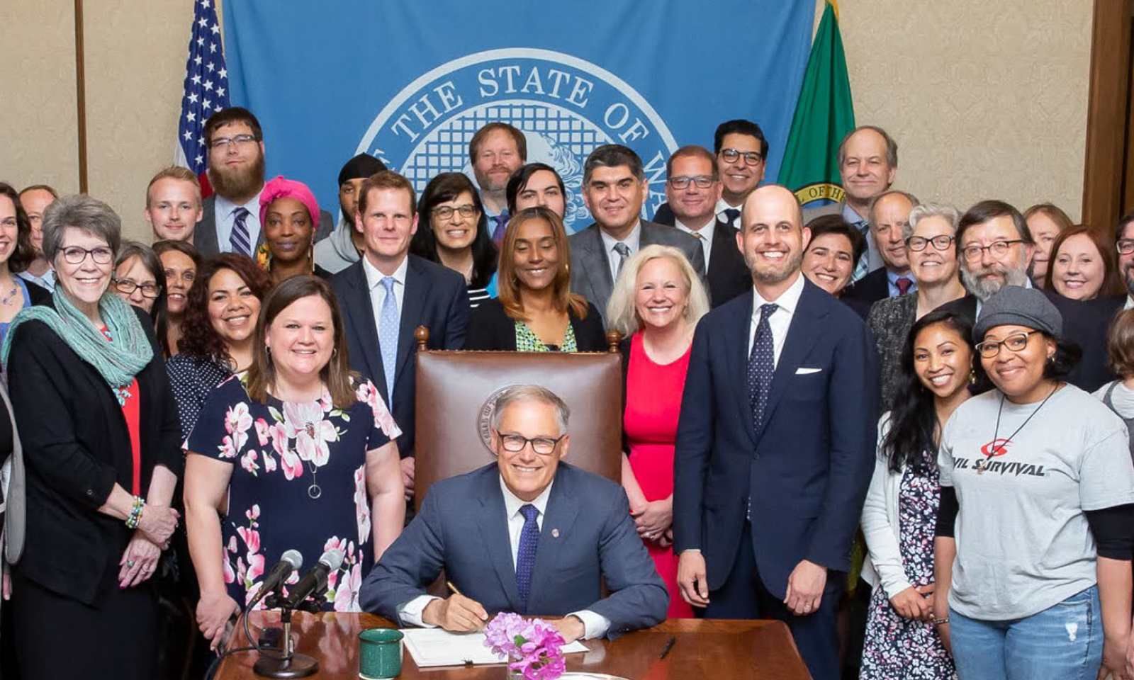 Tarra Simmons stands beside Washington Governor Jay Inslee, who is signing the New Hope Act bill