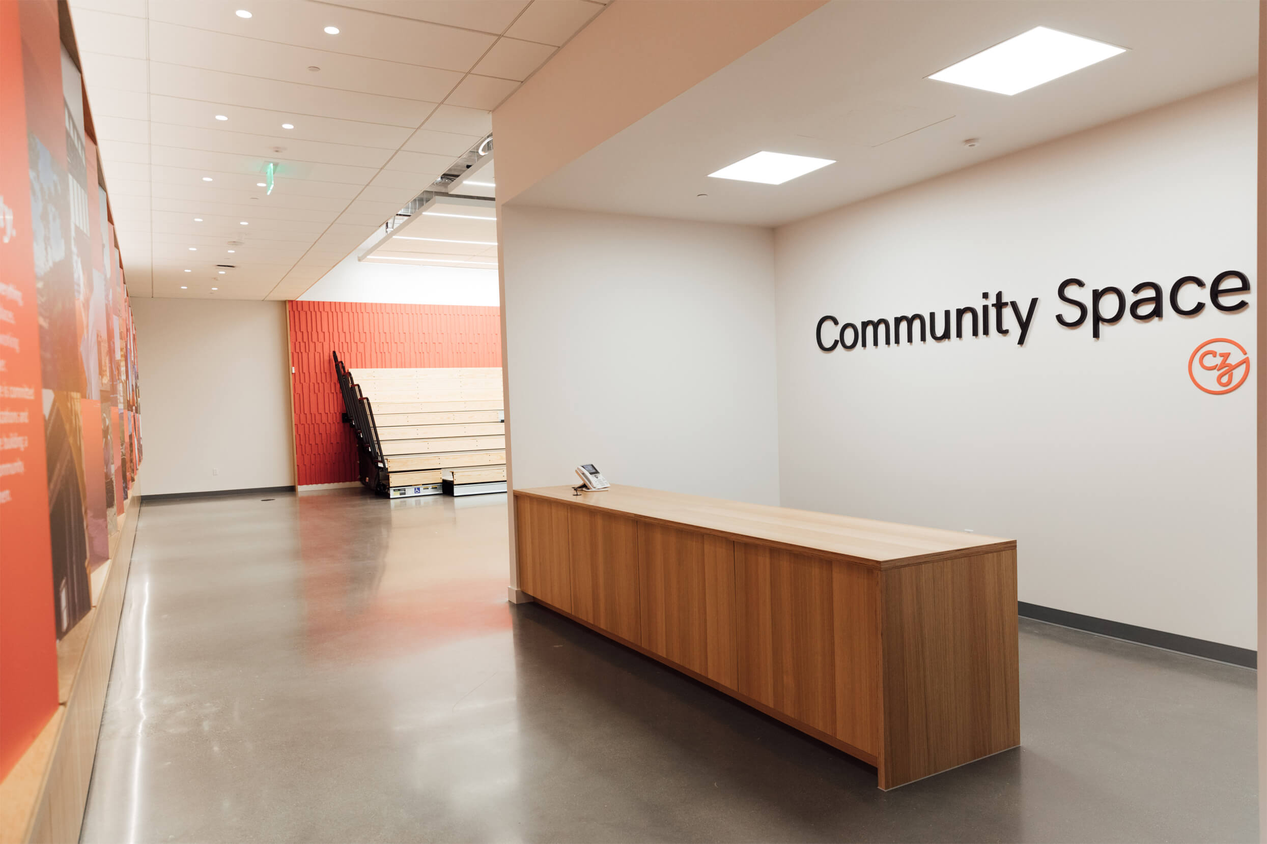 Empty lobby space with a large desk in front of a wall with “Community Space” text and logo.