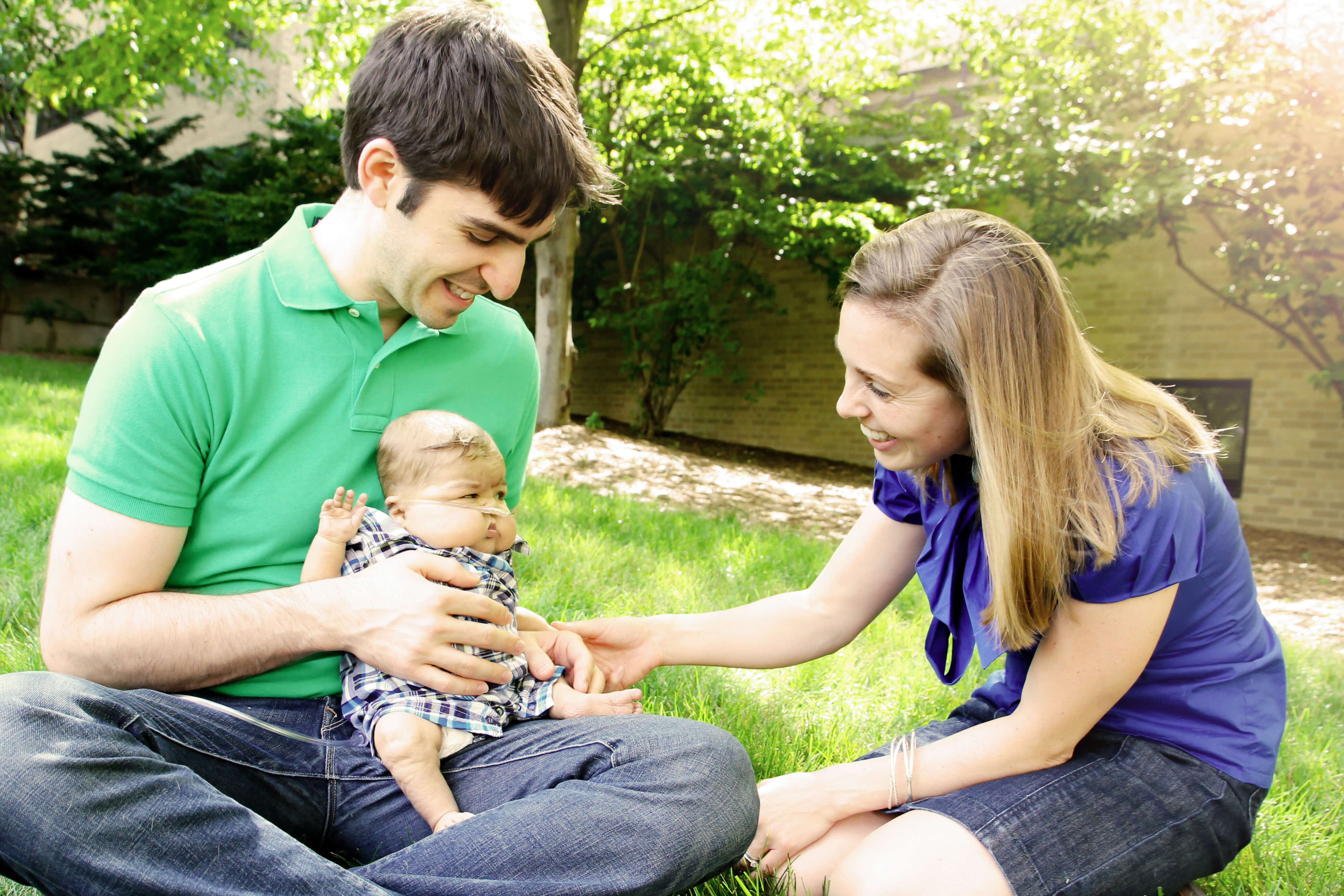 Noah Canvasser (left), son Micah Canvasser (middle), and Jennifer Canvasser play outside on the grass