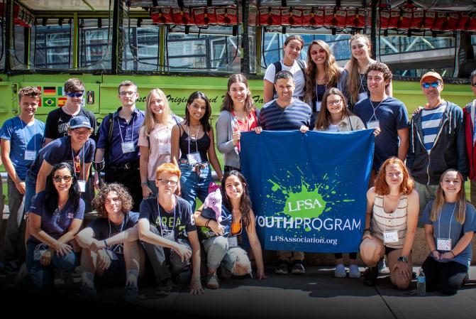 Group of young people at Li-Fraumeni Syndrome Association youth workshop, posing with blue LFSA banner.