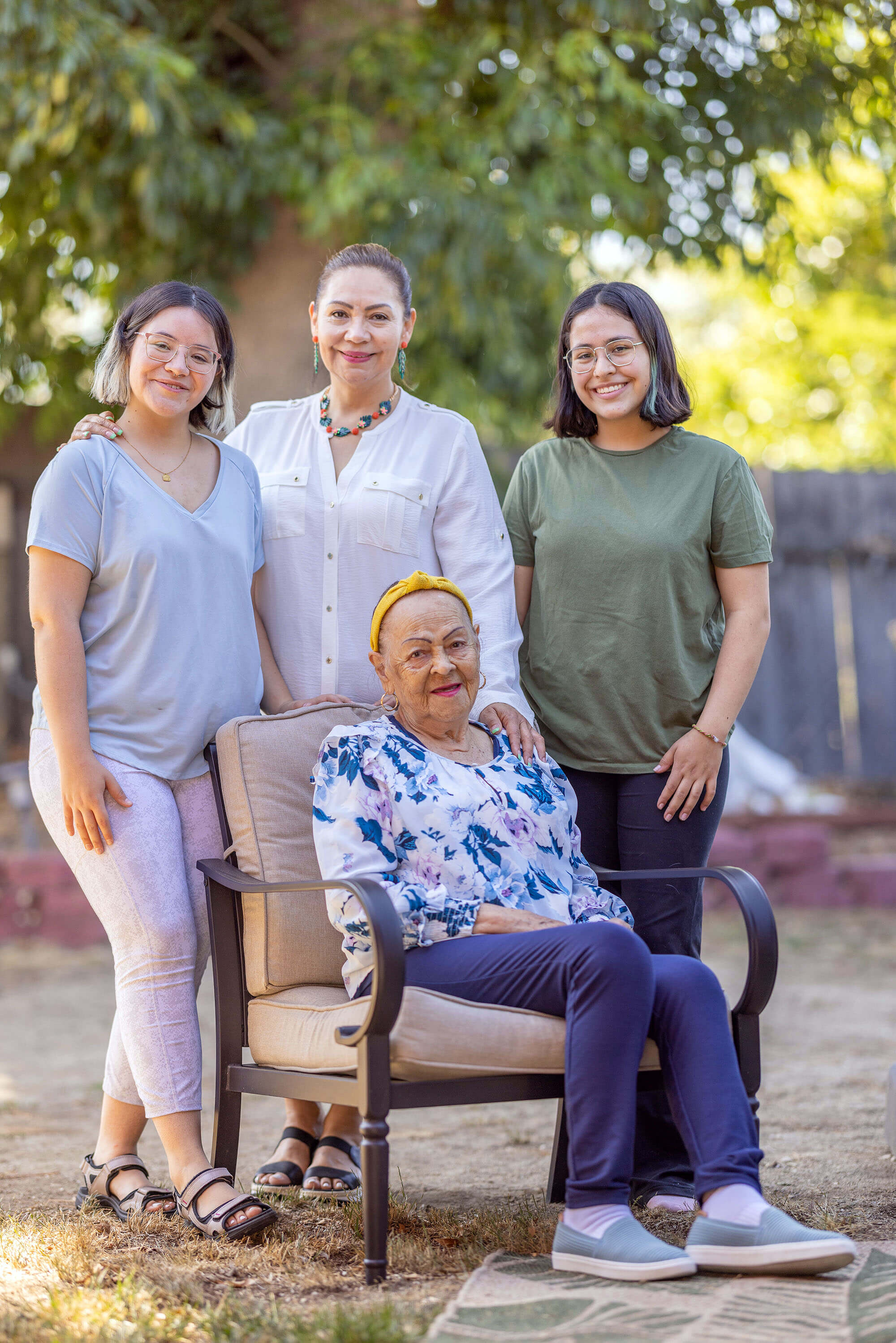 Four women, of three generations, pose for a family portrait.