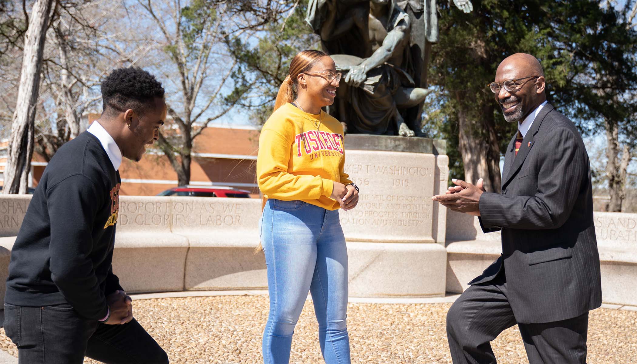 Two Tuskegee University students laugh with S. Keith Hargrove.