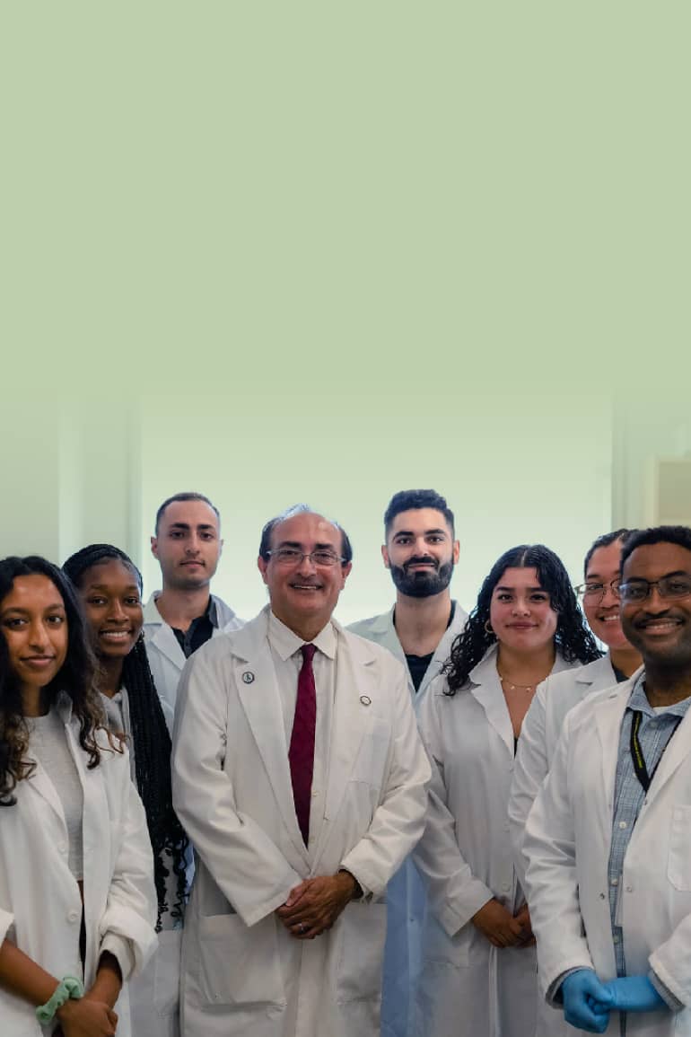 A group of genomics researchers wearing white coats in a lab.