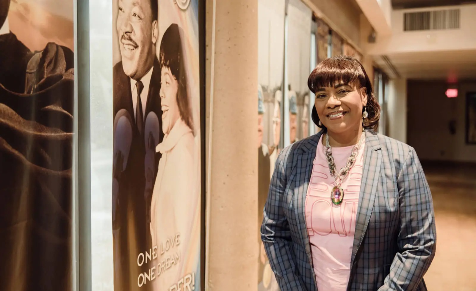 Dr. Bernice A. King smiles next to a poster of Dr. Martin Luther King, Jr. and Coretta Scott King.