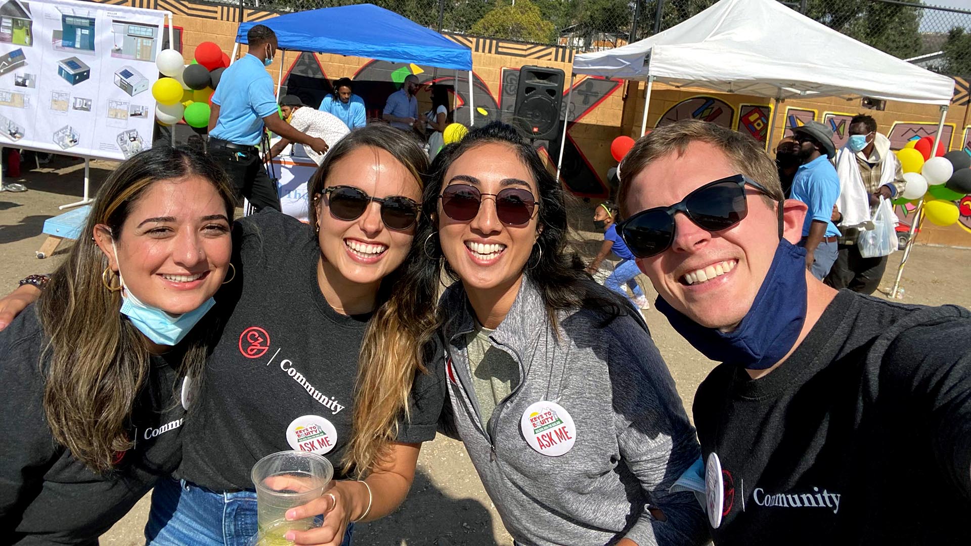 A group of CZI employees smile for a photo at an outdoor community event.