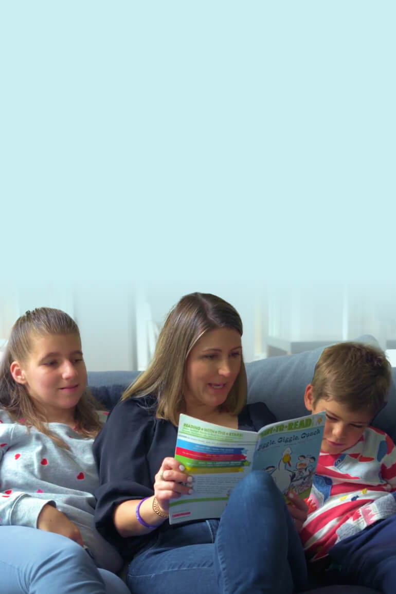 Mother reading to her two children including a teenage daughter and younger son.