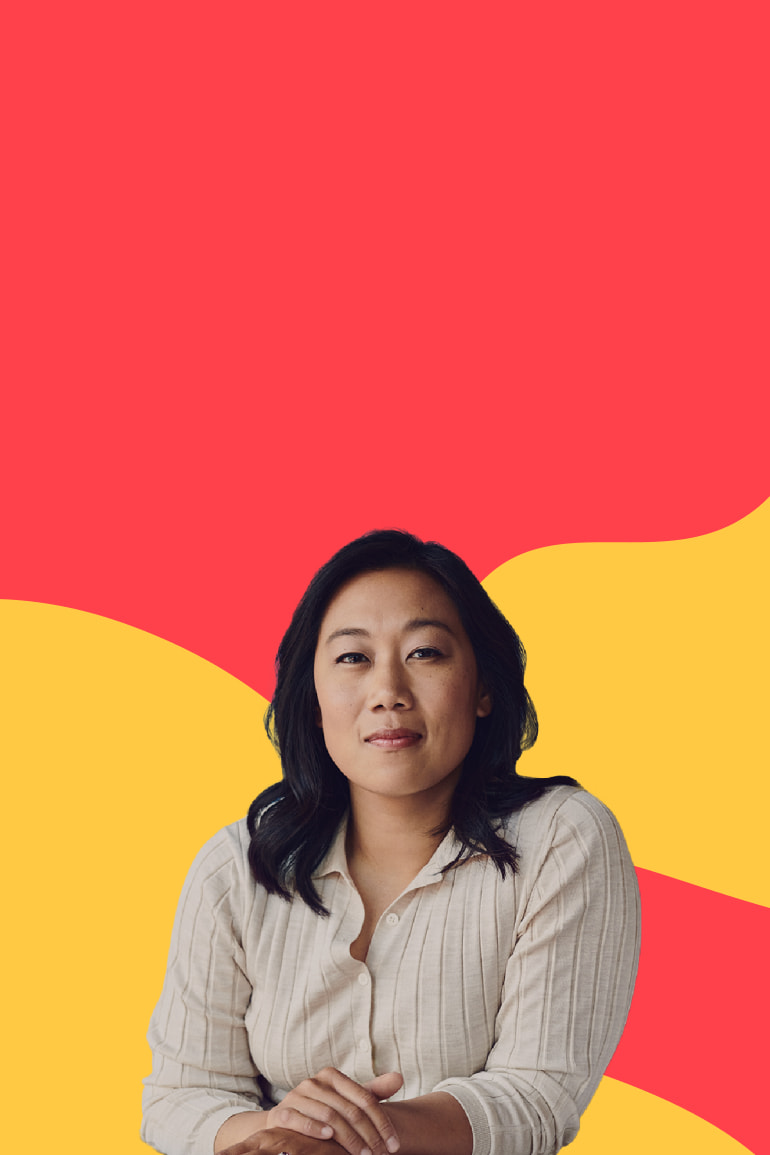 Priscilla Chan, Co-CEO of the Chan Zuckerberg Initiative looking at the camera with her arms folded and in front of a red and yellow illustrated background.