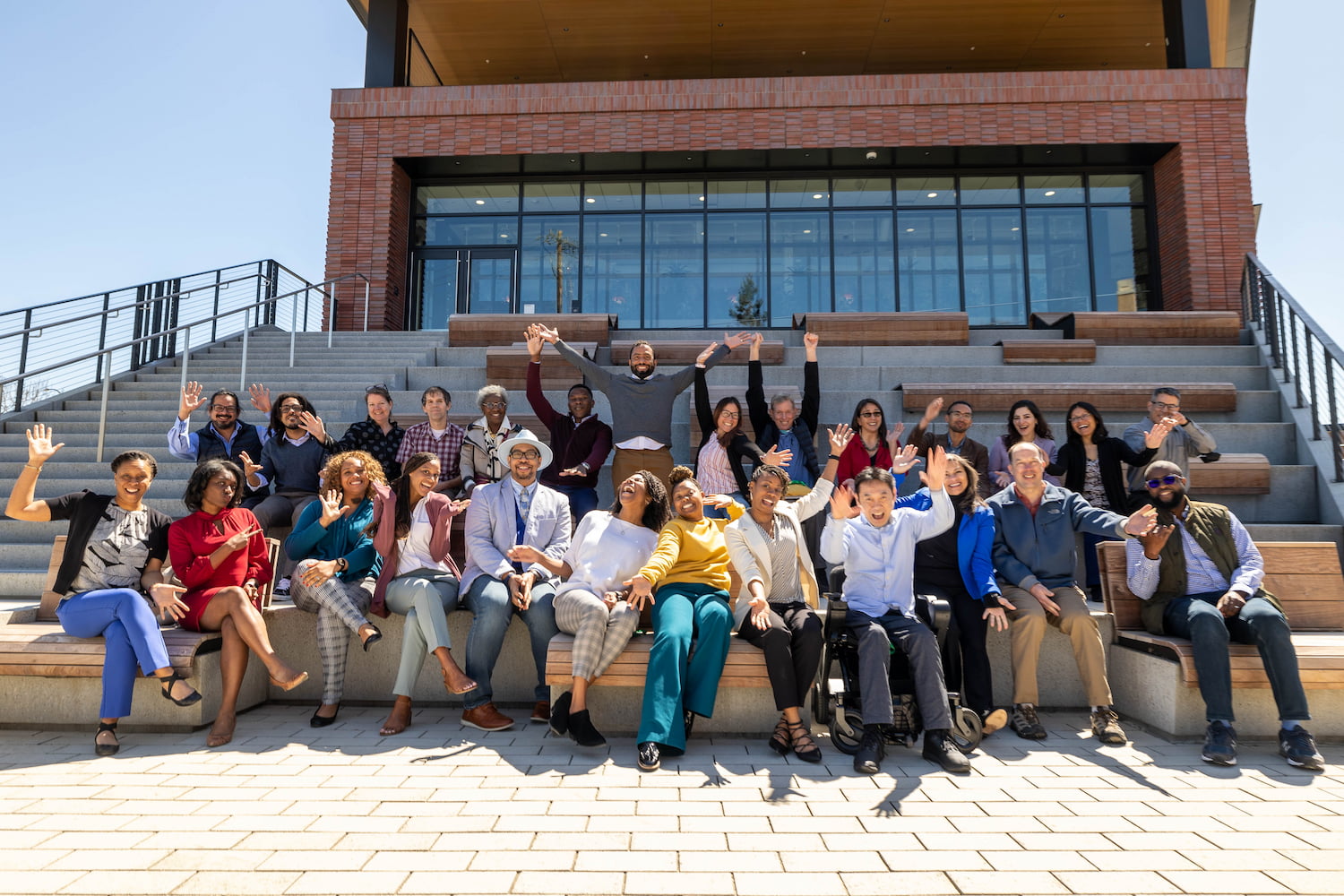 A group of participants at CZI’s Science Diversity Leadership Kickoff Meeting stand side by side outside the CZI HQ and wave at the camera.