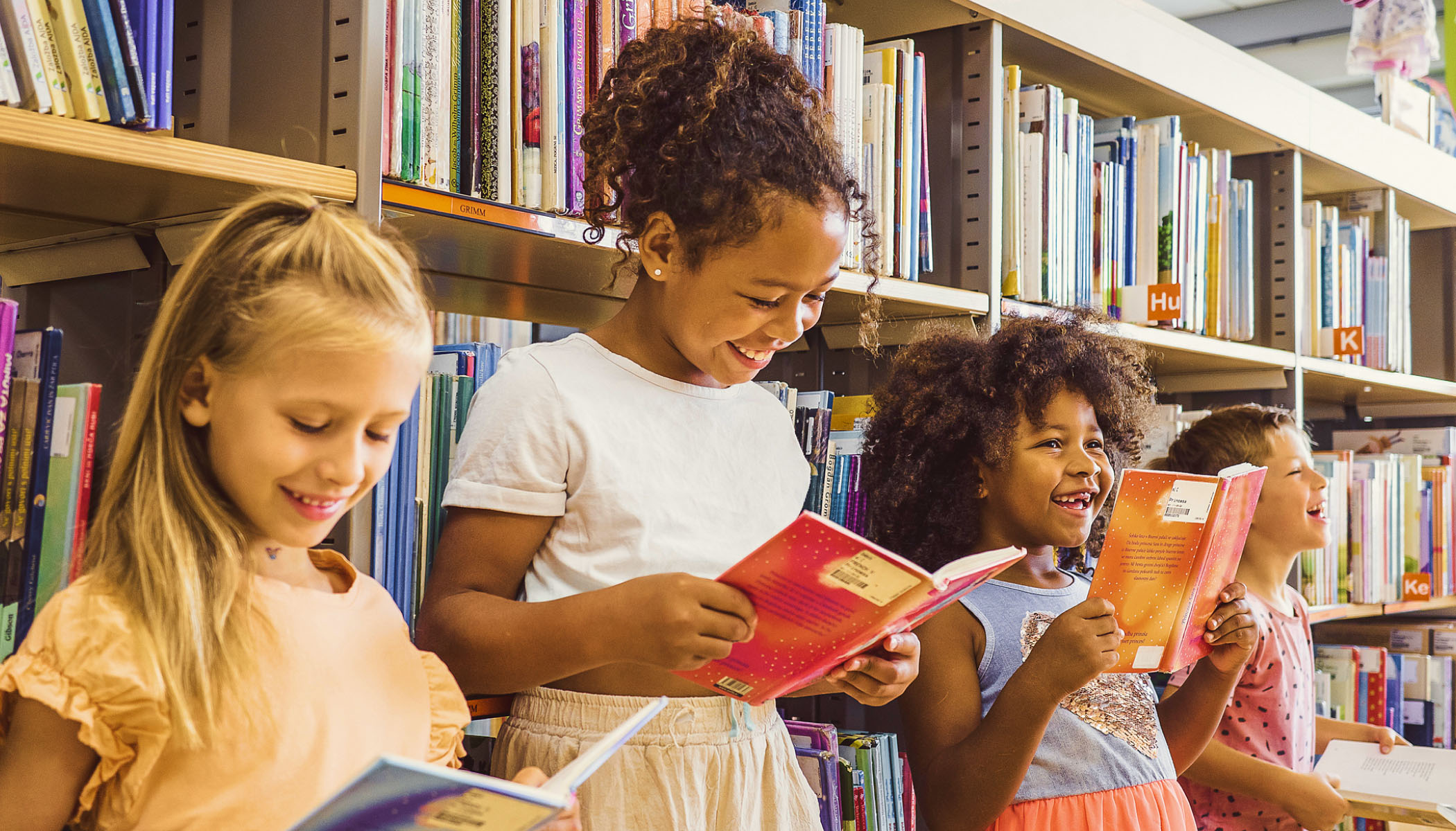 Four children reading books at school