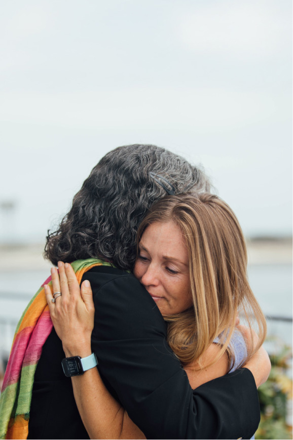 A woman hugging another person and smiling