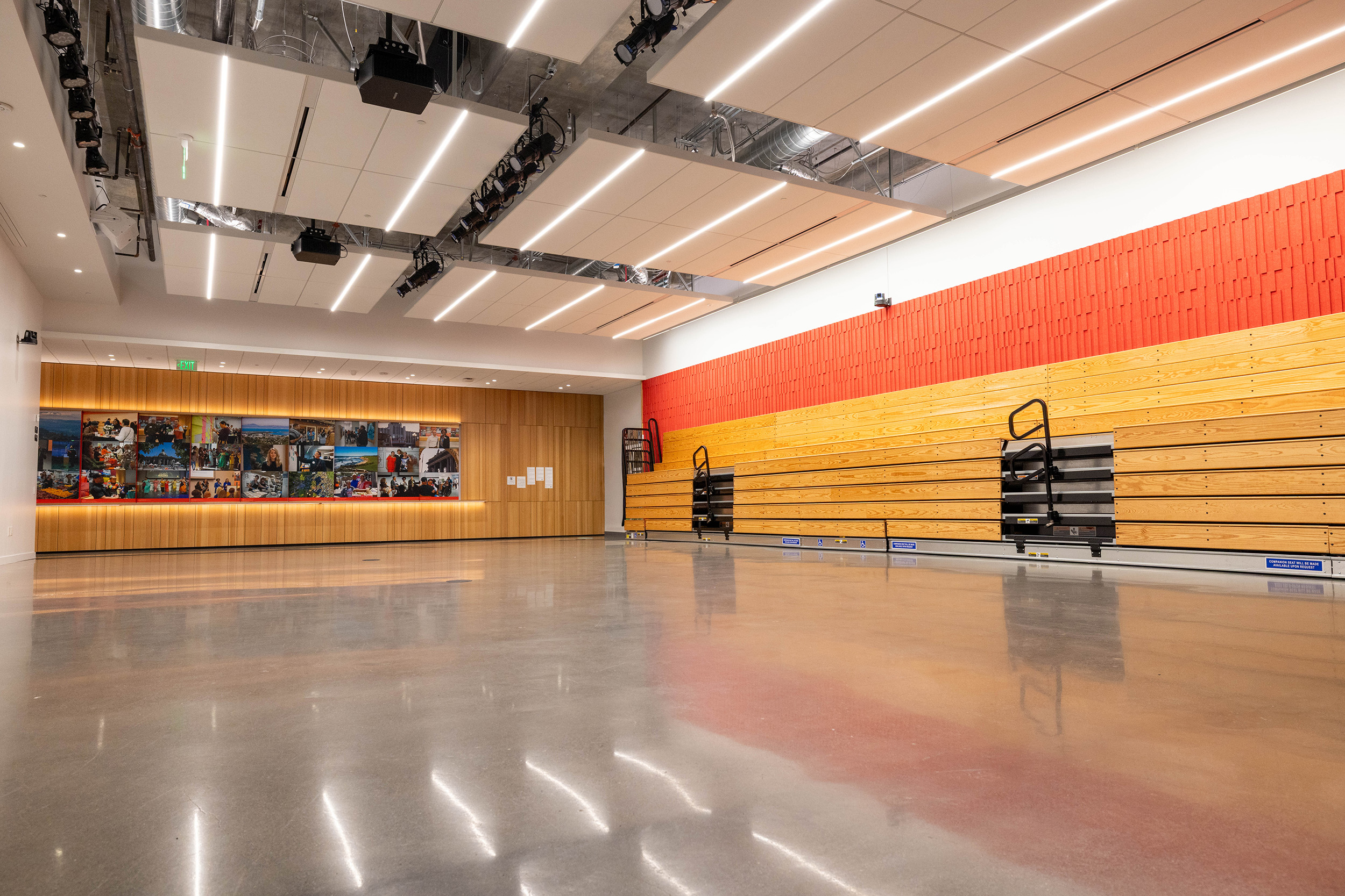 Large empty room with podium and stadium seating on one wall.