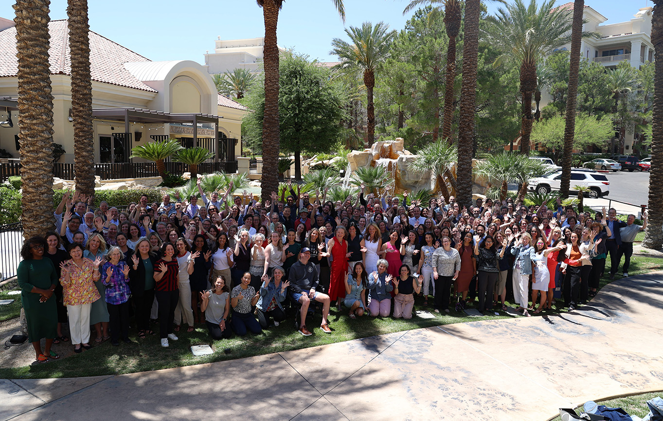 Participants of the Science in Society 2025 Grantee Meeting stand and look up to the camera, waving and smiling outside of the conference center at the JW Marriott Resort at Summerlin in Las Vegas, NV.