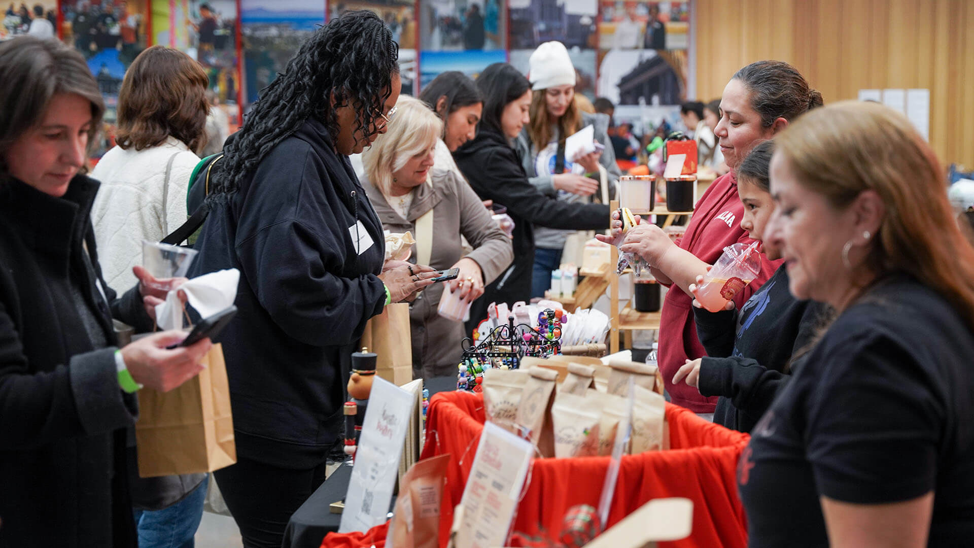 Several people are pictured shopping for items with local vendors.