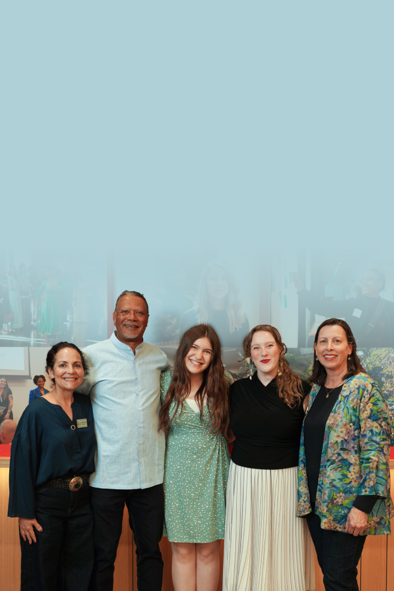 Five people stand closely together and smile at the CZ Community Space.