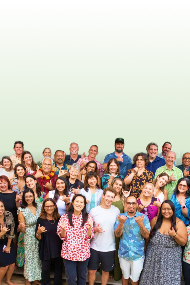 A large gathering of people, including CZI co-founders Priscilla Chan and Mark Zuckerberg, in support of the Chan Zuckerberg Kauaʻi Community Fund, giving shaka signs outdoors.