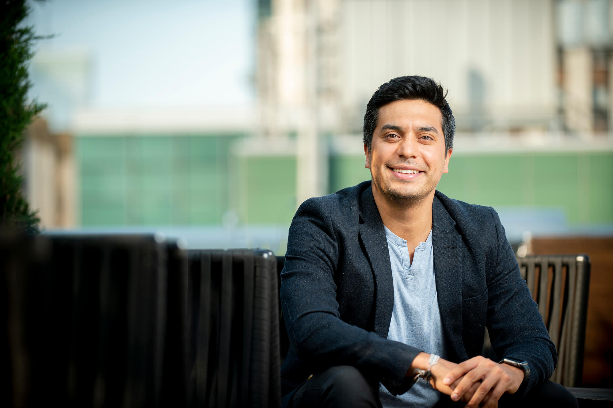 A man in a blazer smiles.