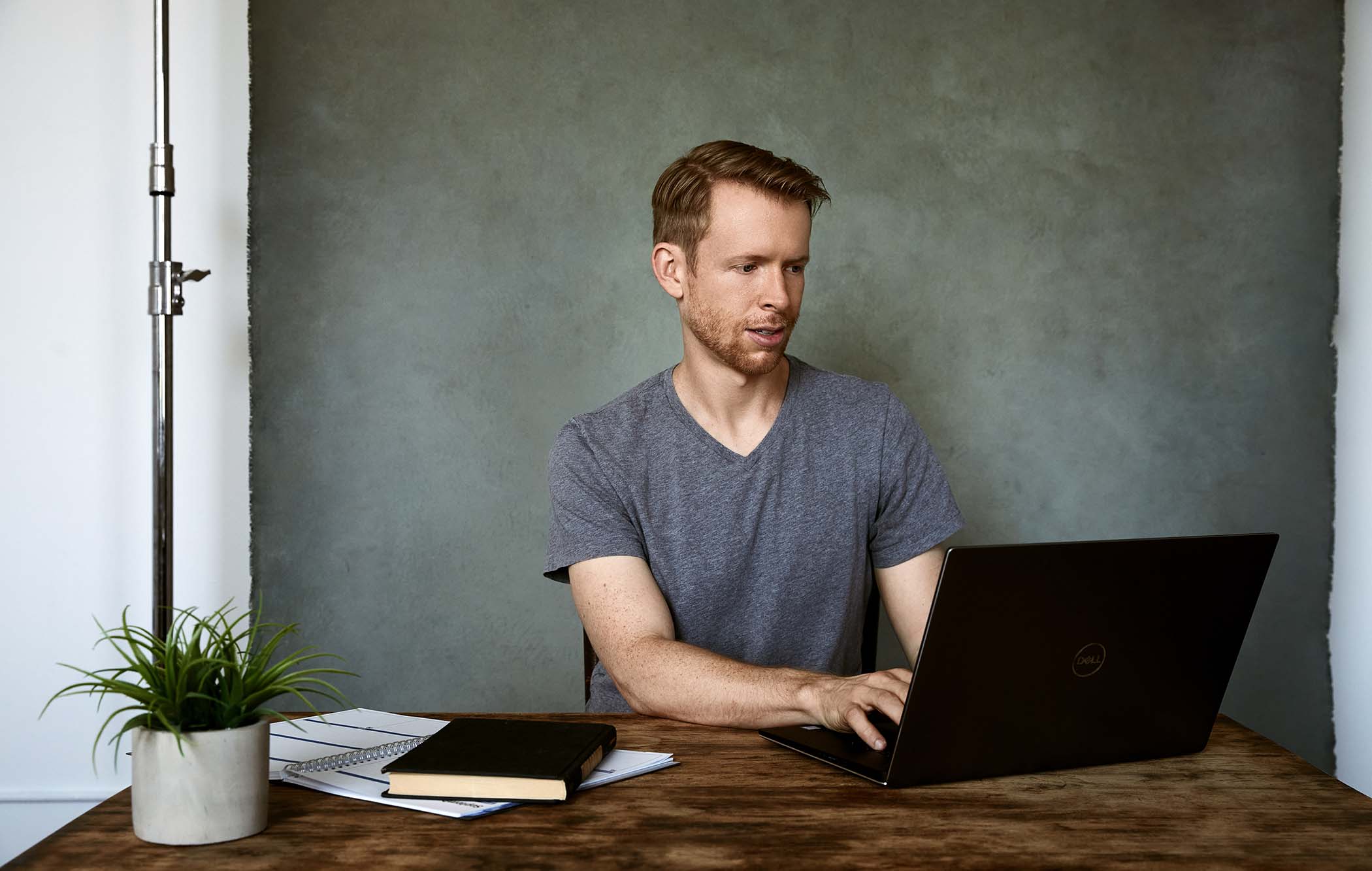 A man works on a computer at a desk.