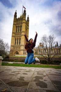 A woman jumps in the air and smiles.