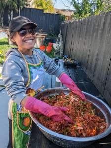 CZI housing affordability manager Michelle smiles while wearing gloves and tossing a bowl of food.