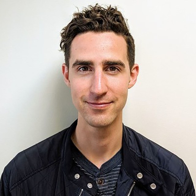 A headshot of Christian smiling.