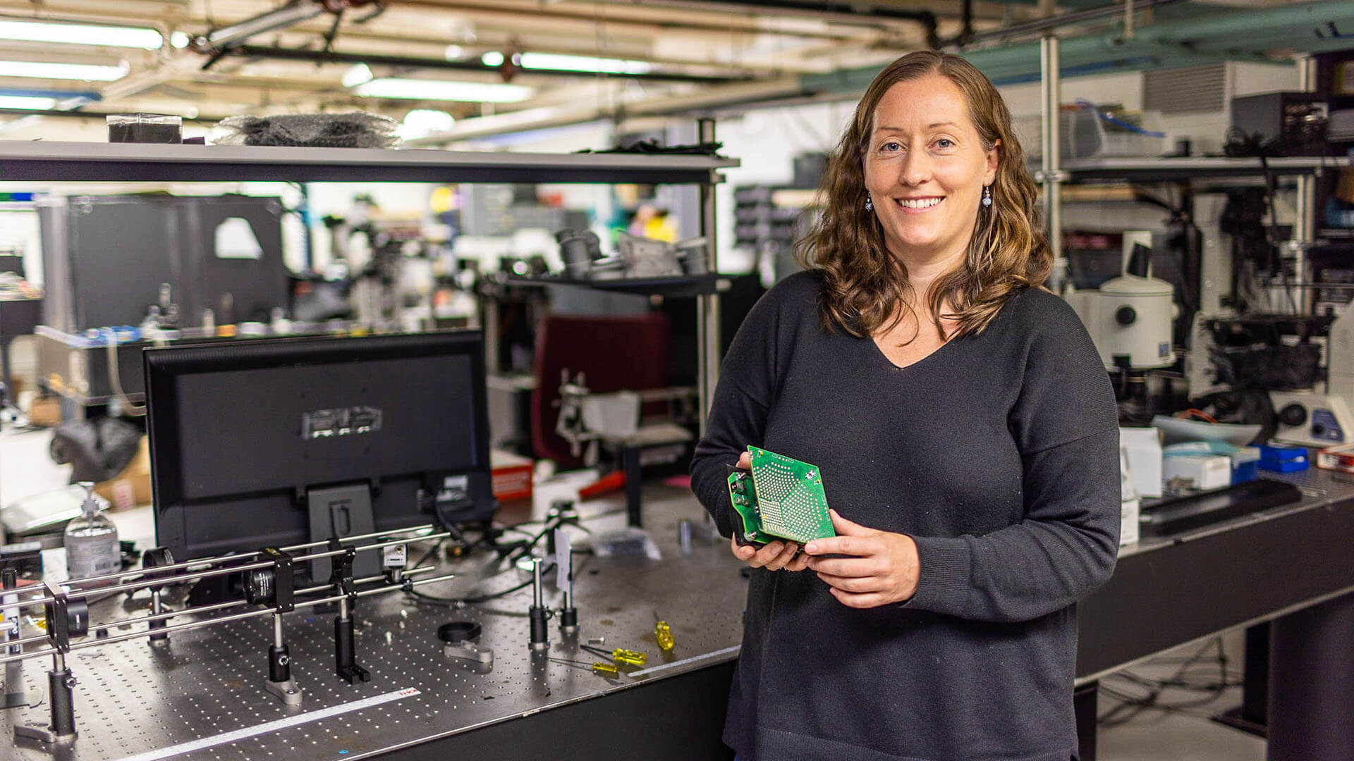 Laura in a computational imaging lab holds a piece of imaging equipment .