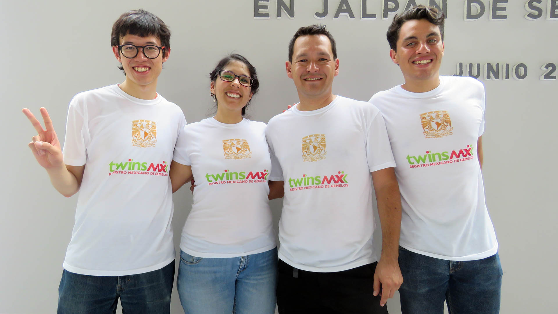 Four people smile wearing white shirts that read “TwinsMX Registro Mexicano de Gemelos.”