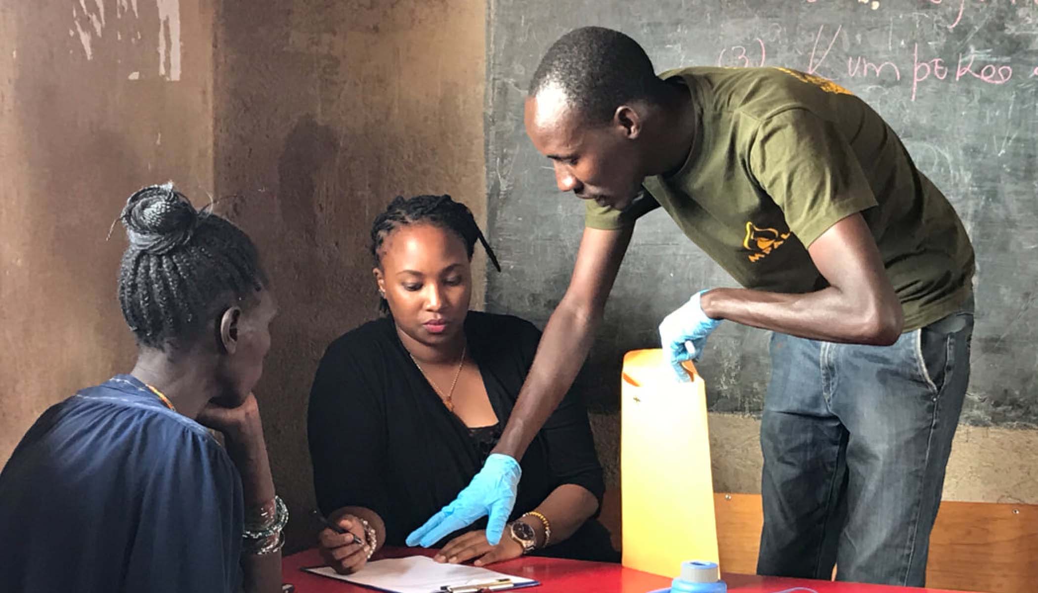 A physician discusses paperwork with two patients.