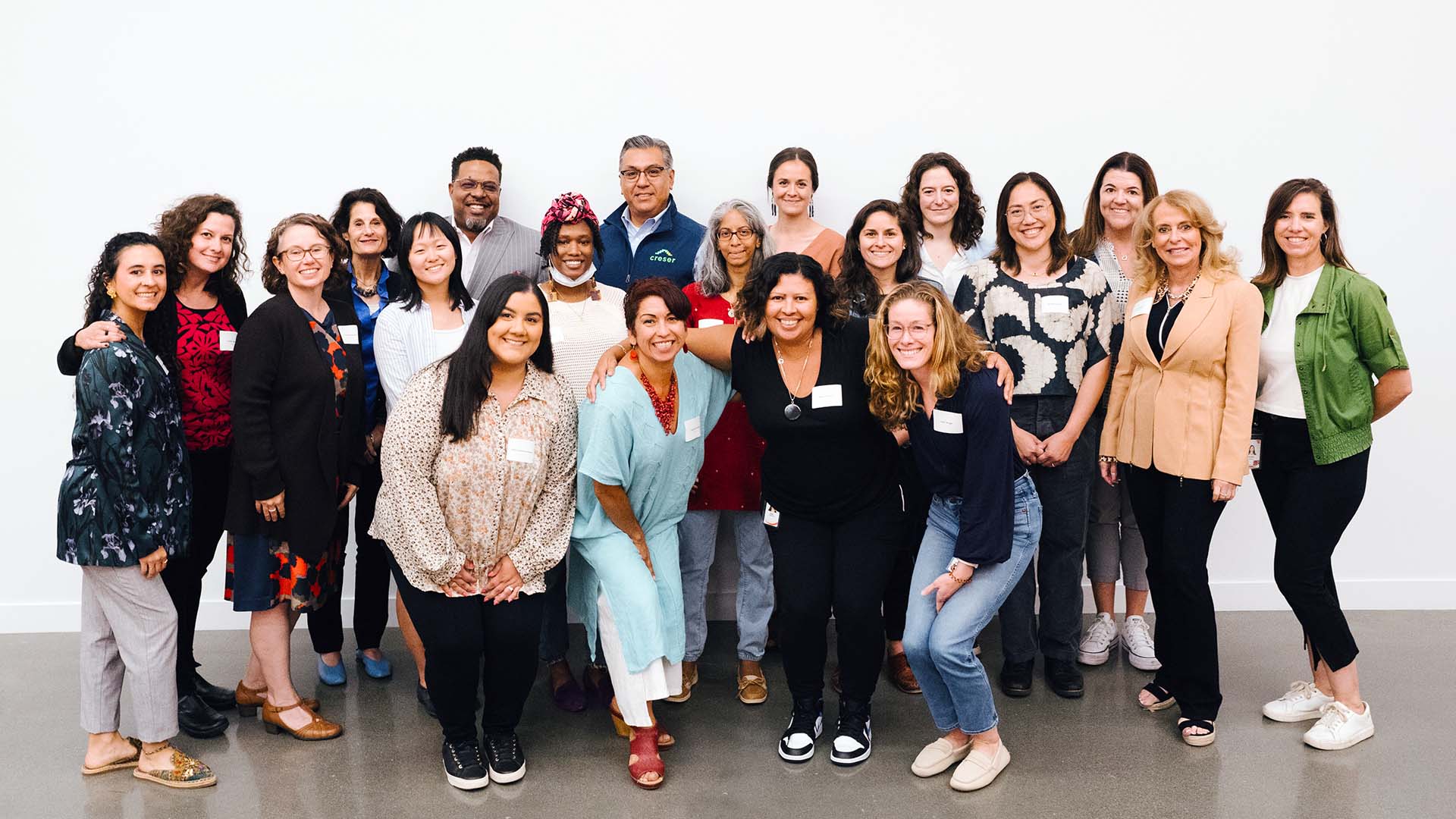 A large group of people smile for a photo.