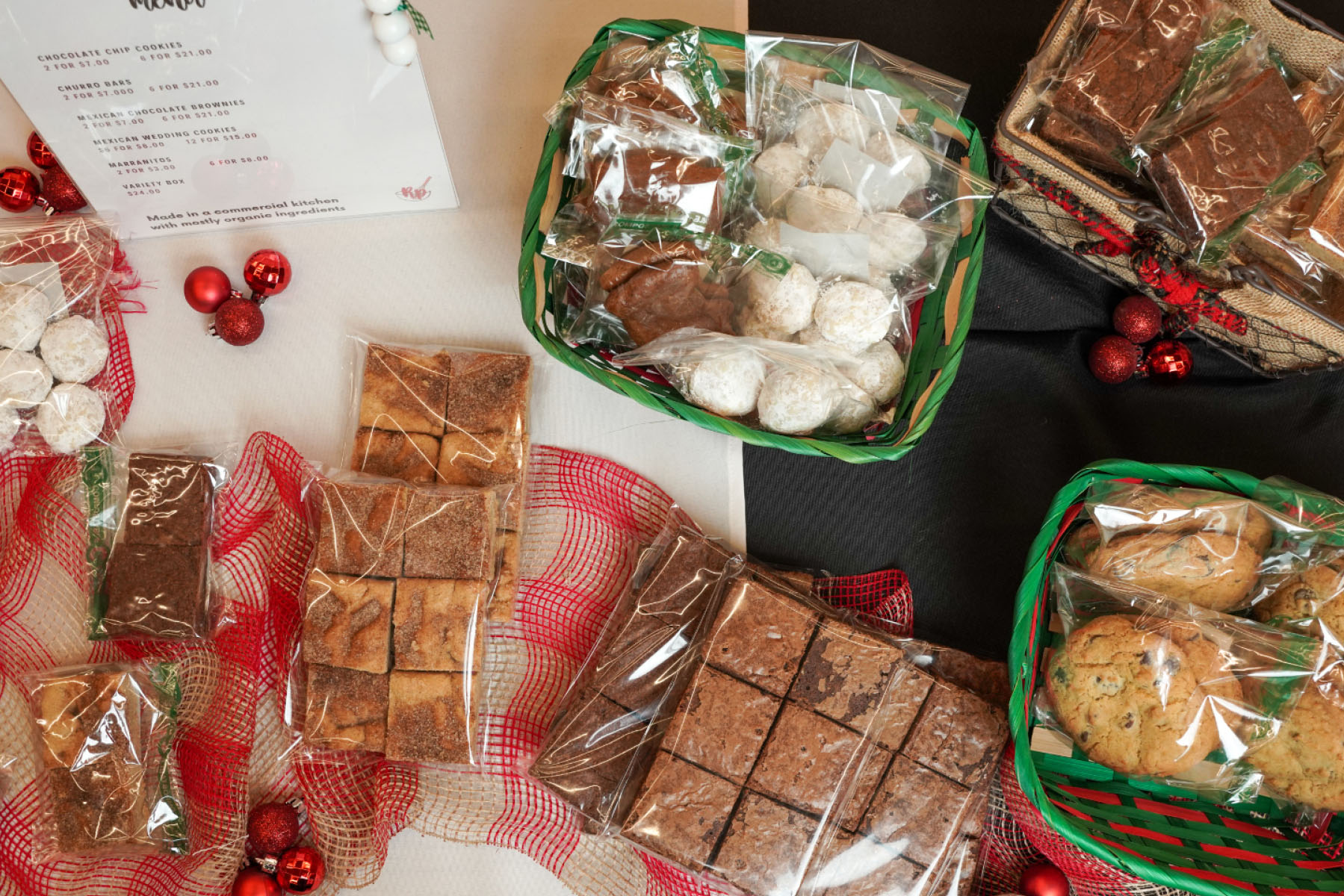 A dessert spread is displayed on a table with red and green detailing.