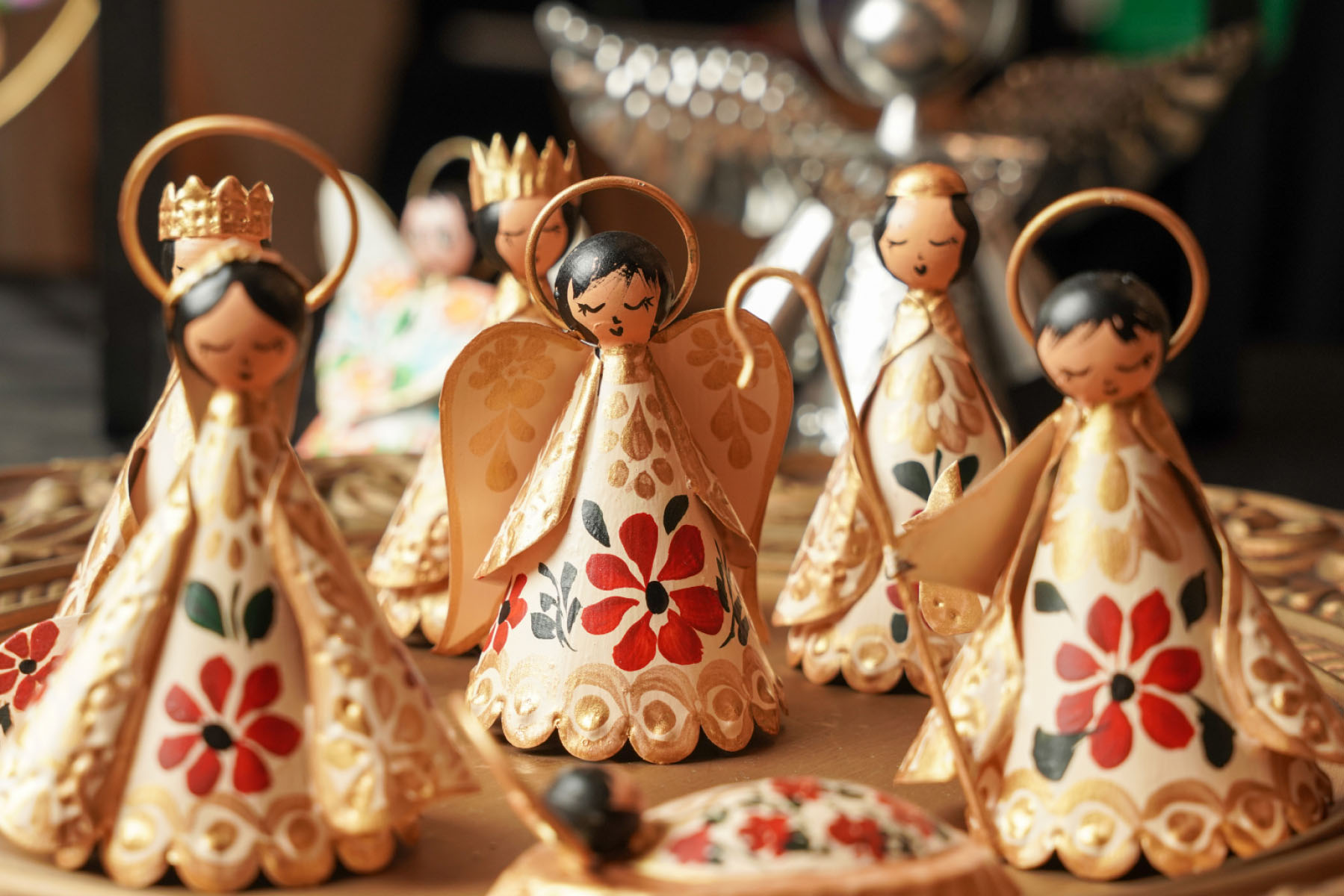 A close up of aluminum, hand-painted angel Christmas ornaments.